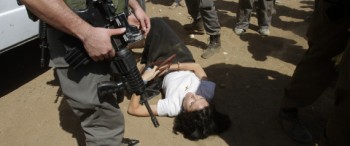 French diplomat Castaing lays on the ground after Israeli soldiers carried her out of her truck in the Jordan Valley